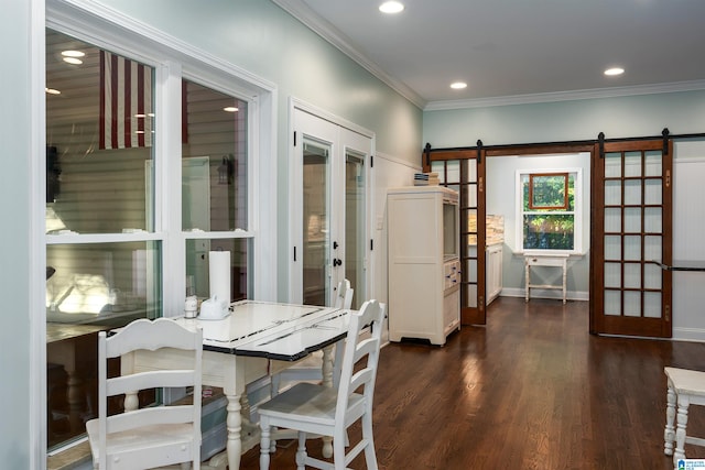 dining room with ornamental molding, a barn door, and dark hardwood / wood-style floors