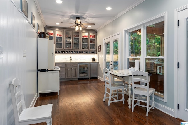 kitchen with wine cooler, ornamental molding, ceiling fan, dark hardwood / wood-style floors, and backsplash