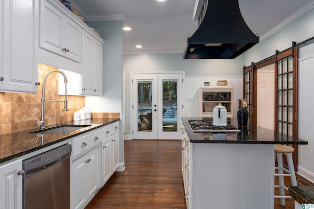 kitchen with french doors, a barn door, dark hardwood / wood-style floors, white cabinetry, and appliances with stainless steel finishes