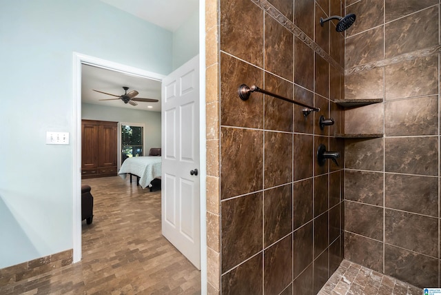 bathroom with ceiling fan, wood-type flooring, and a tile shower