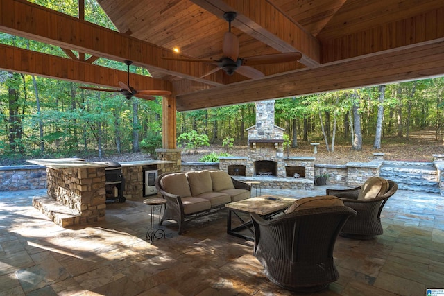 view of patio with ceiling fan and an outdoor living space with a fireplace