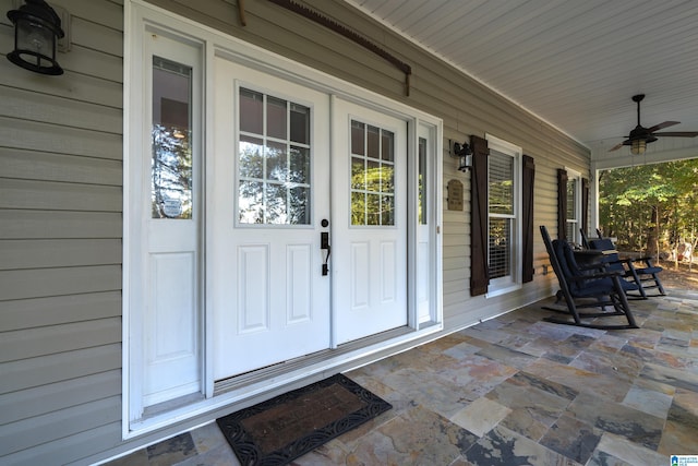 view of exterior entry with covered porch and ceiling fan