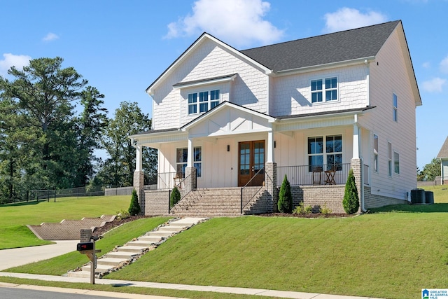 craftsman-style home featuring central AC unit, a front lawn, and covered porch