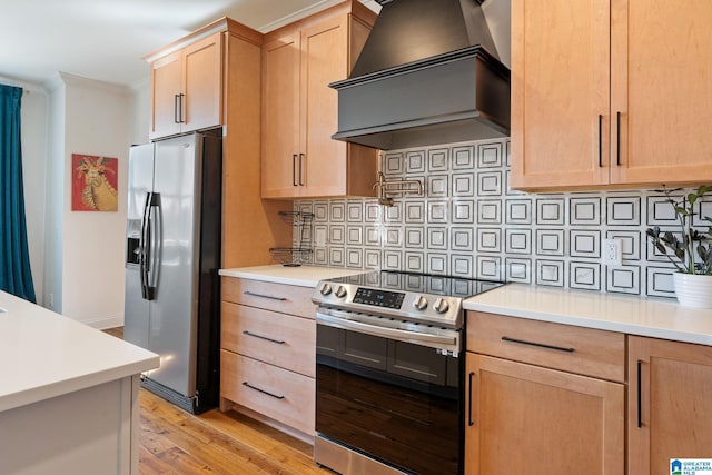 kitchen with light hardwood / wood-style flooring, ornamental molding, backsplash, appliances with stainless steel finishes, and premium range hood