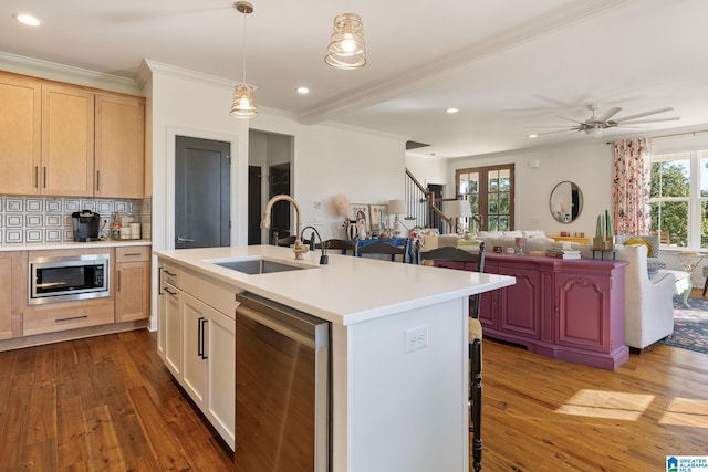 kitchen featuring light brown cabinets, sink, an island with sink, appliances with stainless steel finishes, and a wealth of natural light