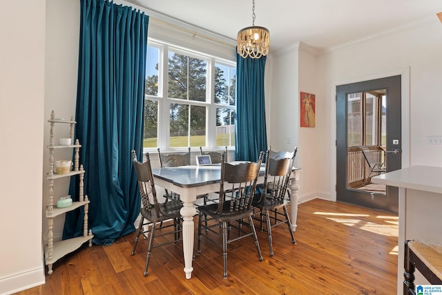 dining area featuring crown molding, hardwood / wood-style floors, and a chandelier