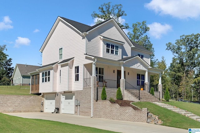 view of front facade with a porch, a front yard, and a garage