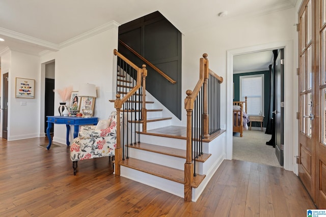 staircase featuring crown molding and hardwood / wood-style floors