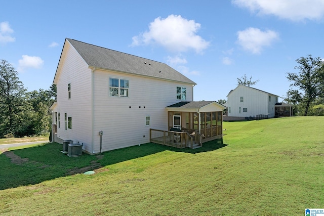 back of house with a wooden deck, a lawn, and a sunroom