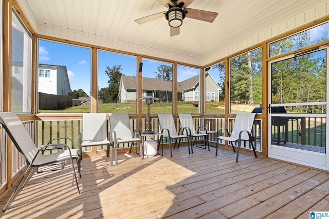 sunroom / solarium featuring ceiling fan, plenty of natural light, and wooden ceiling