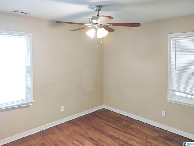 unfurnished room with ceiling fan, dark hardwood / wood-style floors, and a healthy amount of sunlight