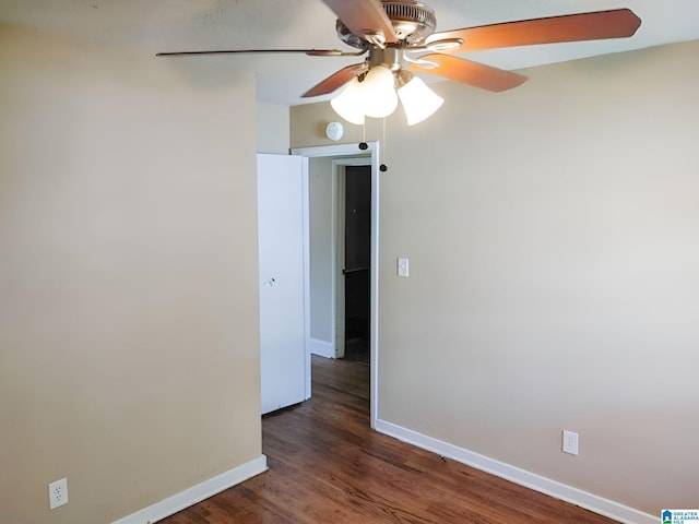 empty room with ceiling fan and dark hardwood / wood-style flooring