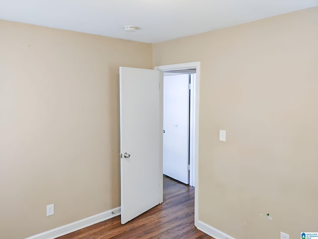 unfurnished room with dark wood-type flooring