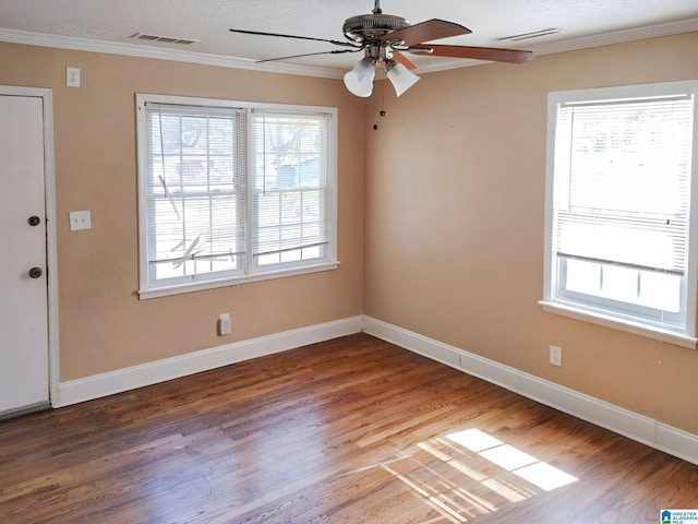 empty room featuring ceiling fan, ornamental molding, a textured ceiling, and hardwood / wood-style floors