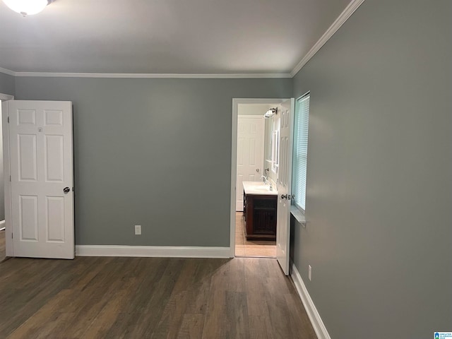 unfurnished bedroom with crown molding, dark wood-type flooring, and connected bathroom