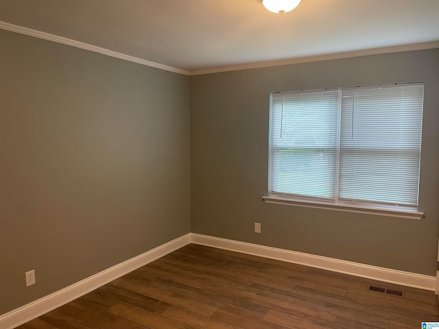 empty room featuring ornamental molding and dark hardwood / wood-style flooring