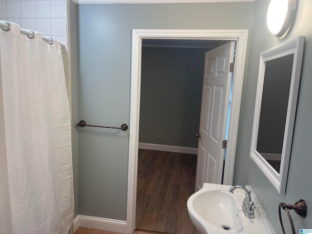 bathroom with hardwood / wood-style flooring, sink, and a shower with shower curtain