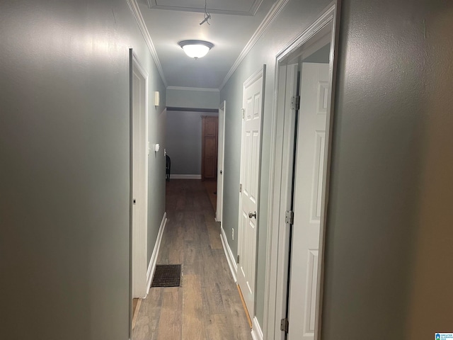 corridor with ornamental molding and hardwood / wood-style flooring