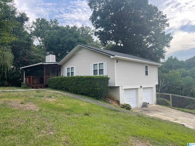 view of side of property with a deck, a lawn, and a garage