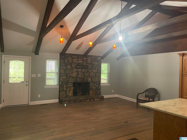 unfurnished living room with a stone fireplace, vaulted ceiling with beams, dark wood-type flooring, and a wealth of natural light