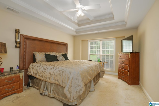 carpeted bedroom with ceiling fan, a tray ceiling, and ornamental molding