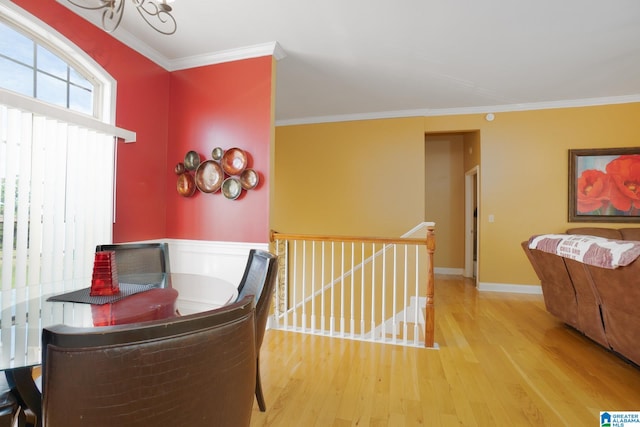 dining area with a notable chandelier, crown molding, and light hardwood / wood-style floors