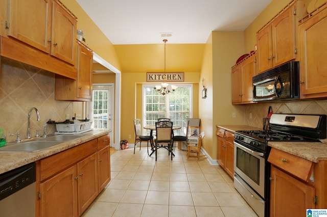 kitchen featuring light tile patterned flooring, hanging light fixtures, sink, appliances with stainless steel finishes, and an inviting chandelier