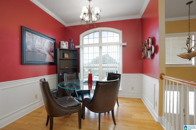 dining space with light hardwood / wood-style floors, a notable chandelier, and ornamental molding