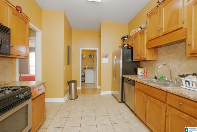 kitchen with backsplash, black appliances, sink, and light tile patterned floors