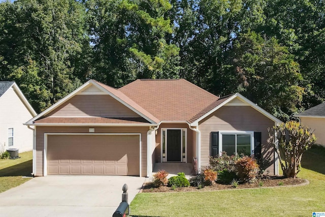 view of front facade with a front lawn, central AC unit, and a garage