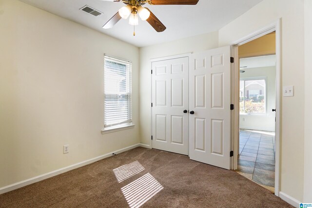 unfurnished bedroom with a closet, ceiling fan, and carpet