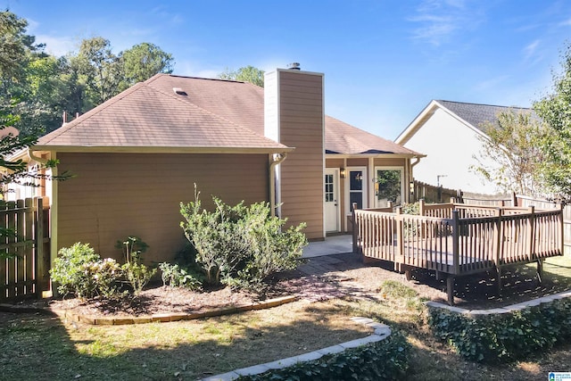 rear view of property featuring a wooden deck