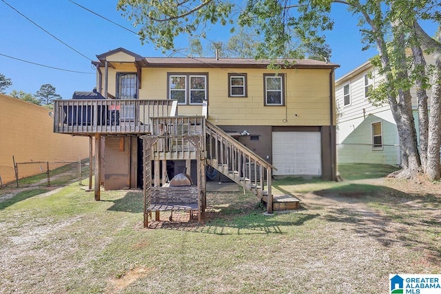 rear view of house with a garage, a deck, and a yard