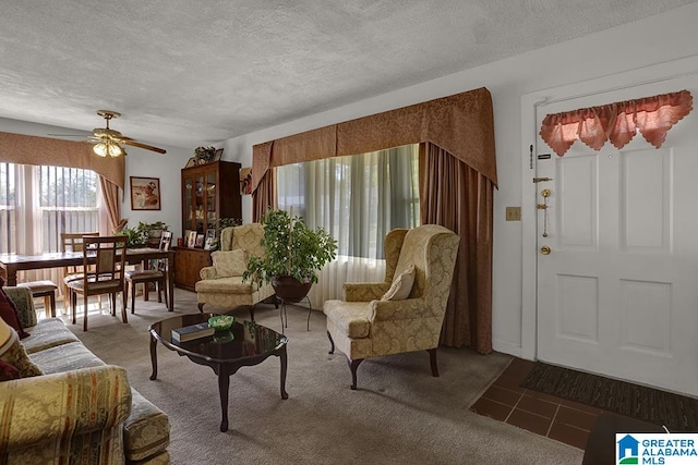 living room featuring carpet, a textured ceiling, and ceiling fan