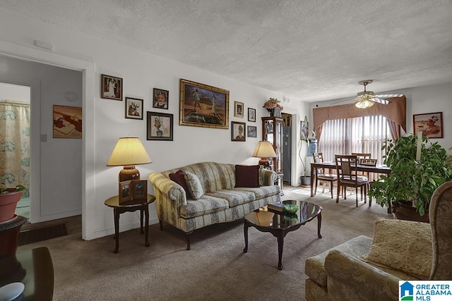 carpeted living room with ceiling fan and a textured ceiling