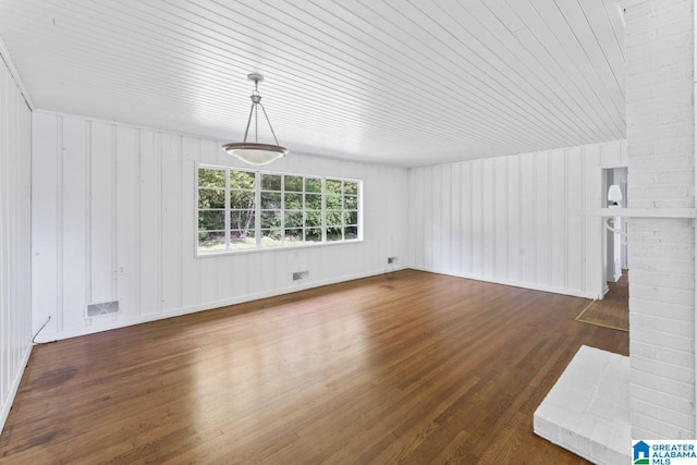 unfurnished living room featuring wood ceiling, a brick fireplace, and dark hardwood / wood-style floors