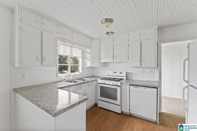 kitchen featuring white appliances, sink, kitchen peninsula, white cabinetry, and light hardwood / wood-style flooring