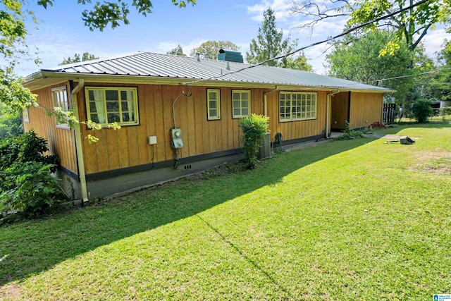 view of home's exterior with central AC and a yard