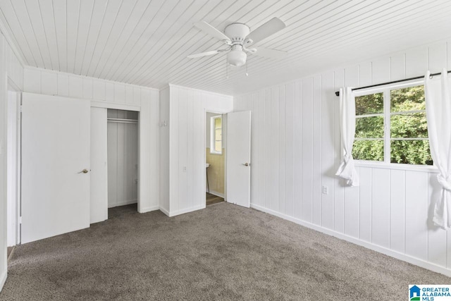 unfurnished bedroom featuring wood ceiling, carpet flooring, a closet, and ceiling fan