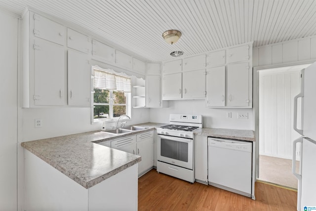 kitchen featuring white appliances, sink, light wood-type flooring, kitchen peninsula, and white cabinetry