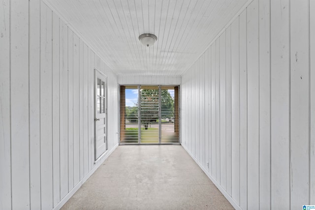 corridor featuring wooden walls