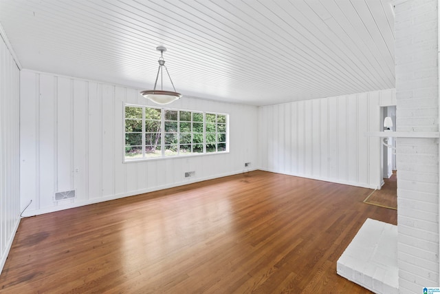 unfurnished living room with a fireplace, dark hardwood / wood-style floors, and wooden ceiling