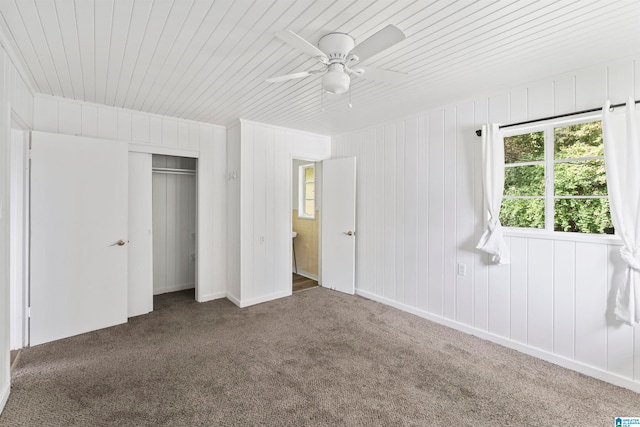 unfurnished bedroom featuring a closet, wood ceiling, carpet, and ceiling fan