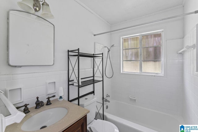 full bathroom with tile walls, toilet, ornamental molding, vanity, and tiled shower / bath combo