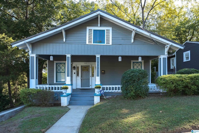 bungalow-style home featuring a front lawn and covered porch