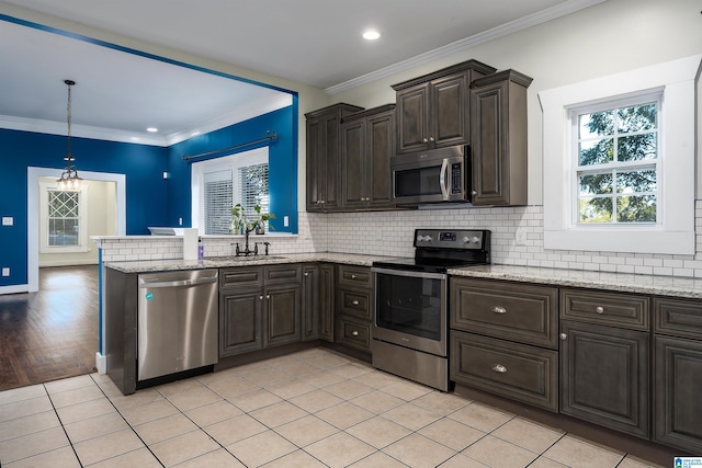 kitchen with sink, ornamental molding, light hardwood / wood-style floors, appliances with stainless steel finishes, and decorative light fixtures