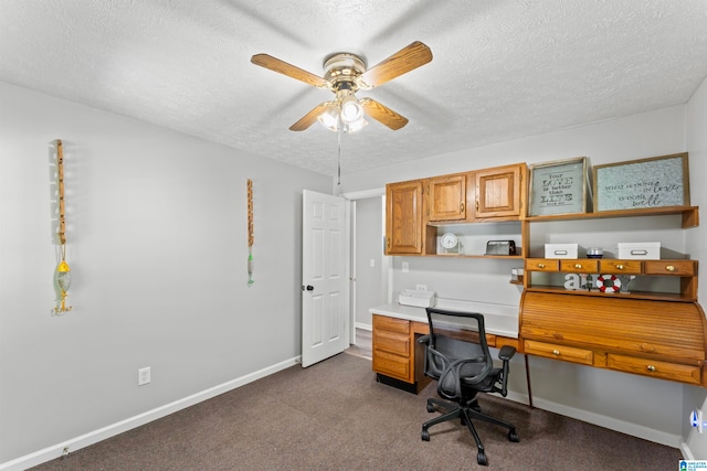 carpeted office space featuring ceiling fan and a textured ceiling