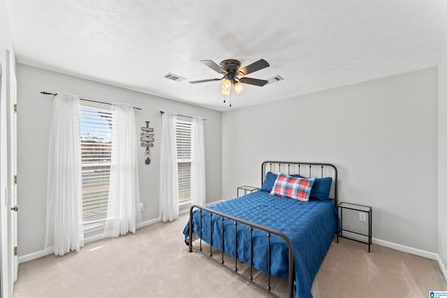 carpeted bedroom with ceiling fan and a textured ceiling