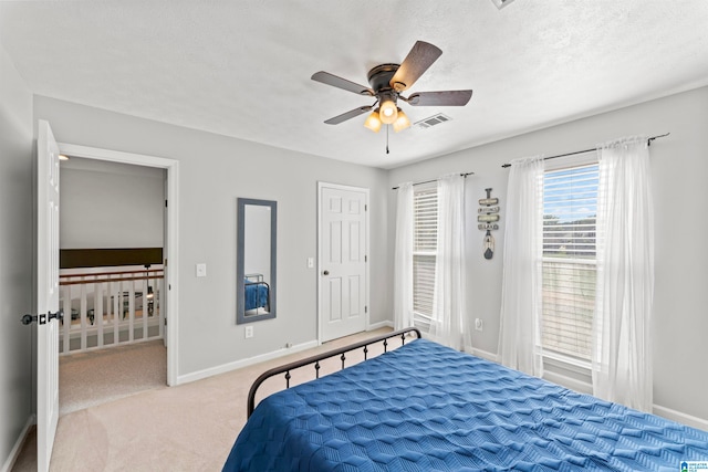 bedroom with light carpet, a textured ceiling, and ceiling fan