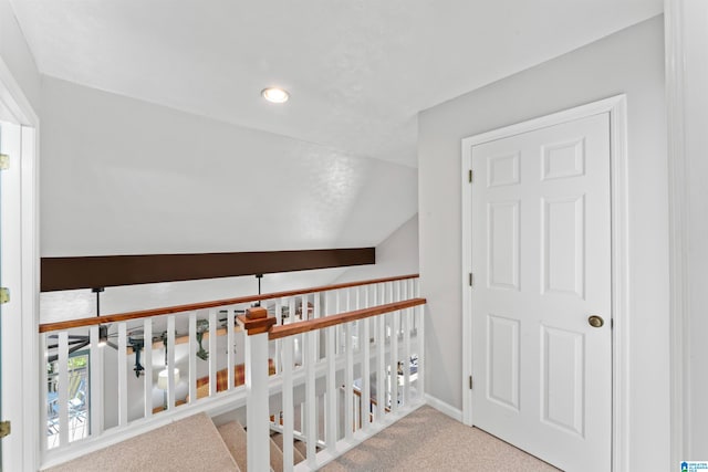 hallway featuring lofted ceiling and carpet